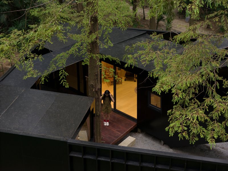 Overhead view of a figure standing at the threshold between timber deck and illuminated interior