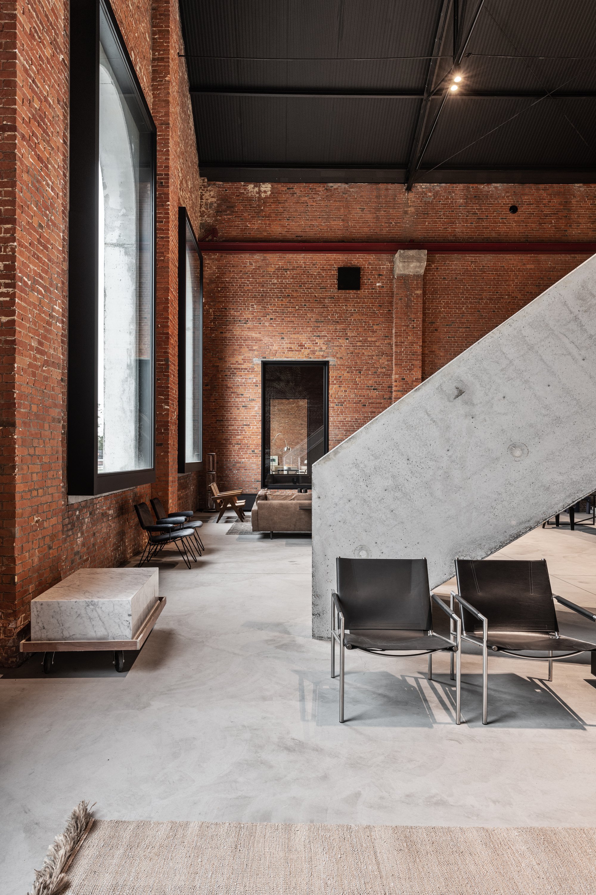 Objekt Architecten Pours a Concrete Disc Through an Aalst Weaving Mill Turned Showroom