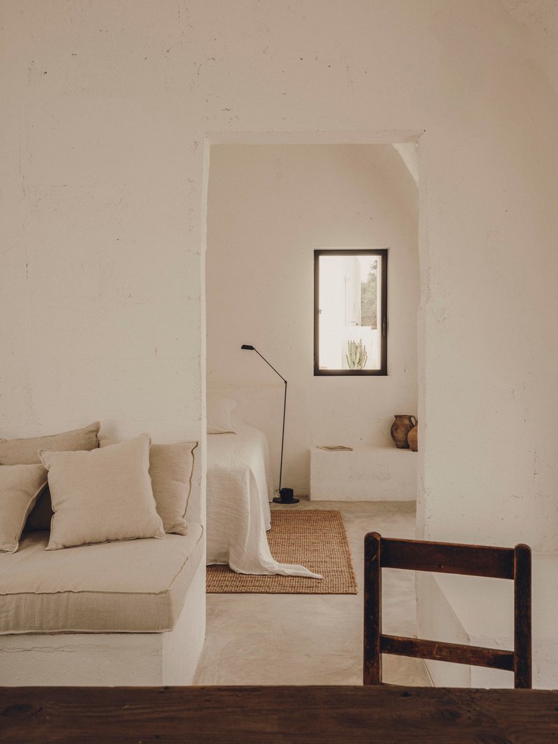 Arched doorway framing a vaulted alcove with portrait window and polished concrete floor in afternoon light