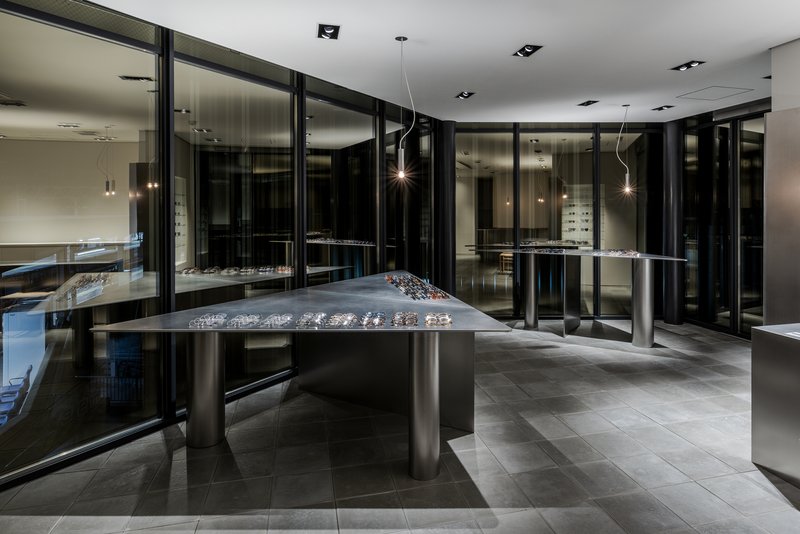 Evening view of the showroom interior with reflections in black glass partition walls