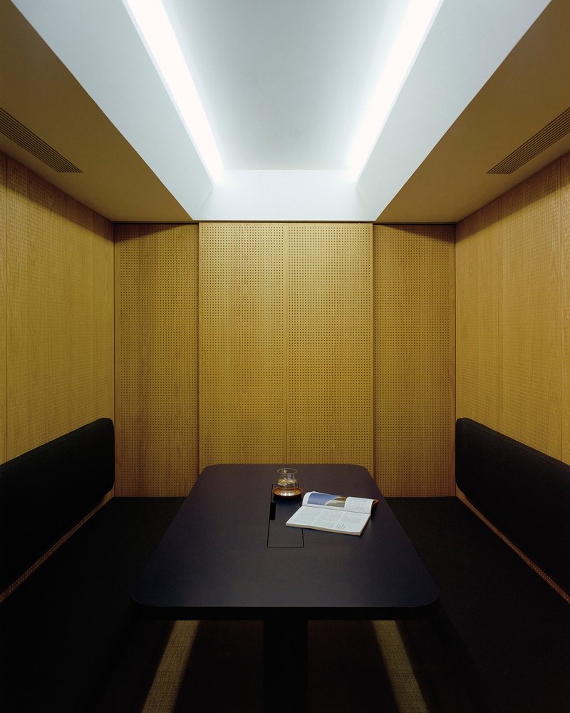 Enclosed booth with woven gold panels and recessed ceiling illumination