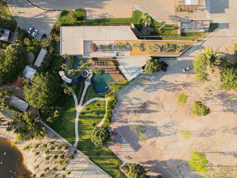Aerial view of curving terraced plaza with organic planting beds and paved pathways connecting landscape features
