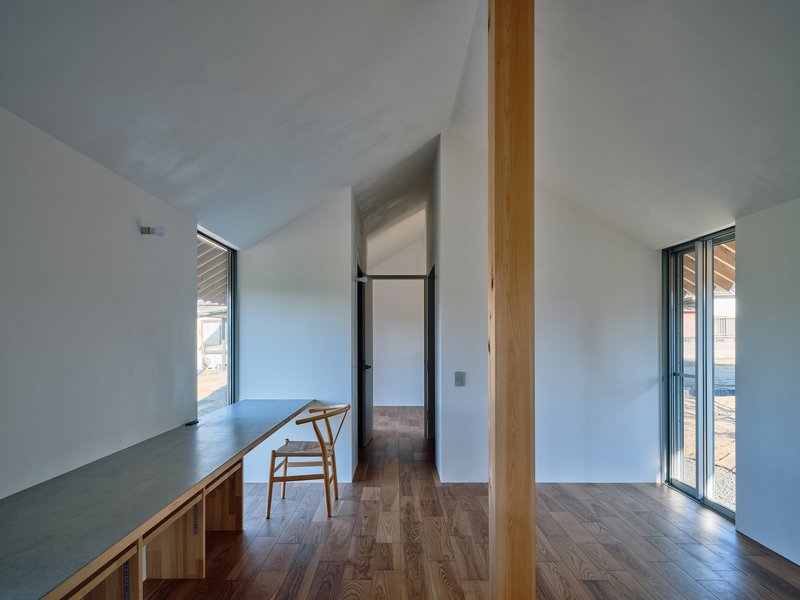 Interior hallway view with single timber column framing passage to adjacent rooms under vaulted ceiling