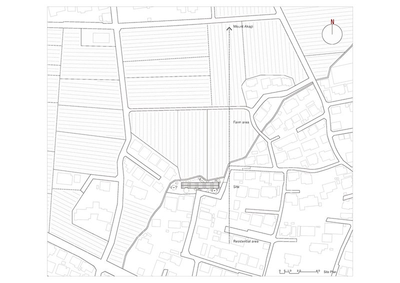 Site plan drawing showing the elongated building footprint among farm plots and residential fabric