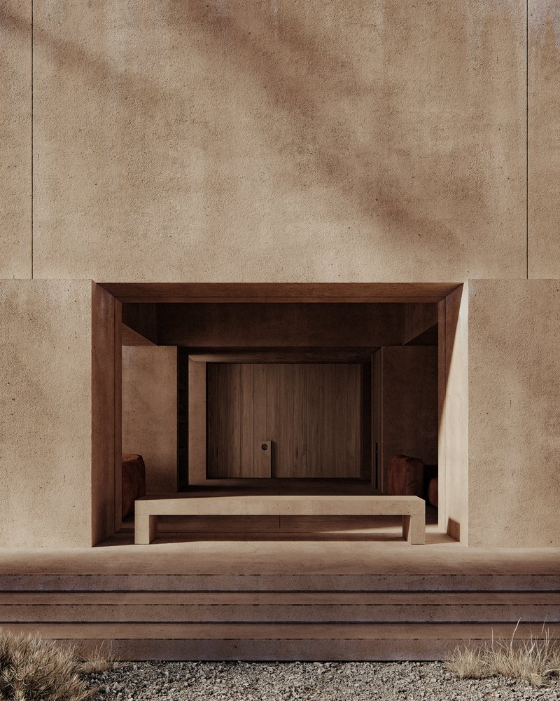 Recessed timber entrance framed by rammed earth walls and timber steps with gravel foreground