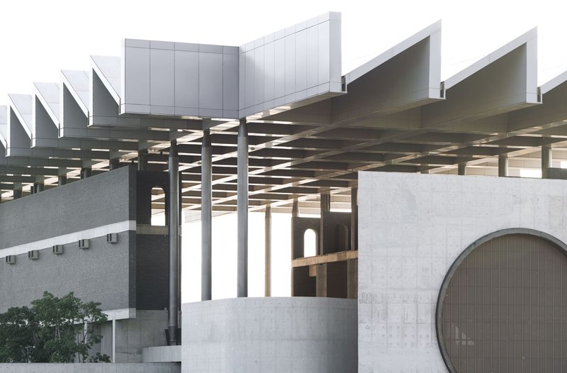 Architectural model showing coffered canopy structure and intersecting concrete volumes with circular and arched openings