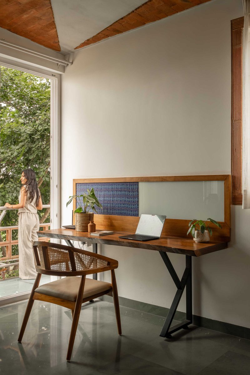 Writing desk alcove with glass and patterned tile backsplash beside a balcony door with garden view