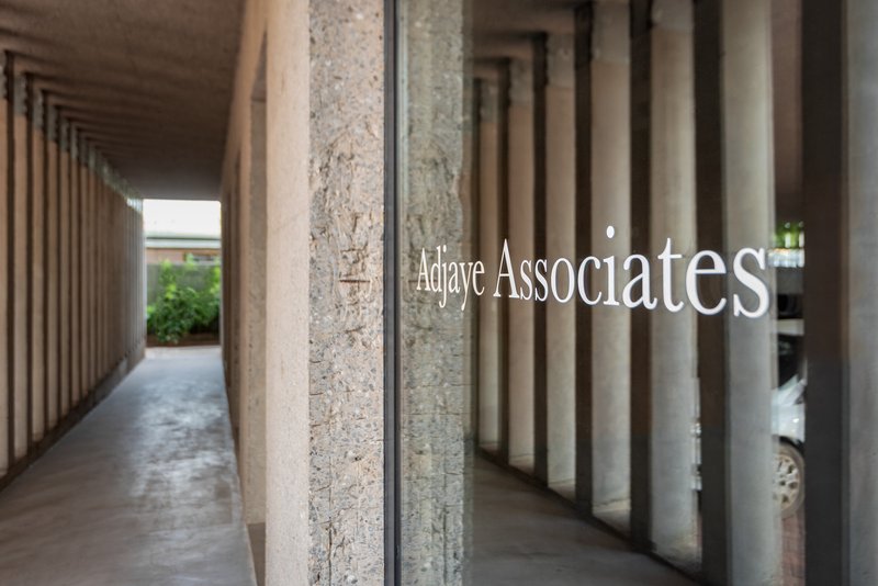 Covered walkway showing the repeating rhythm of concrete columns and exposed aggregate texture in daylight