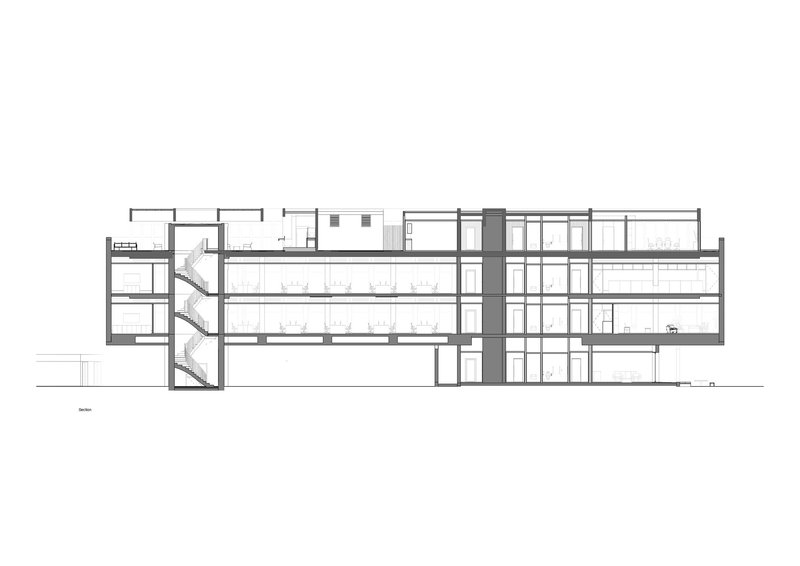 Longitudinal section drawing showing scissor stairs at left and double-height spaces throughout the horizontal building