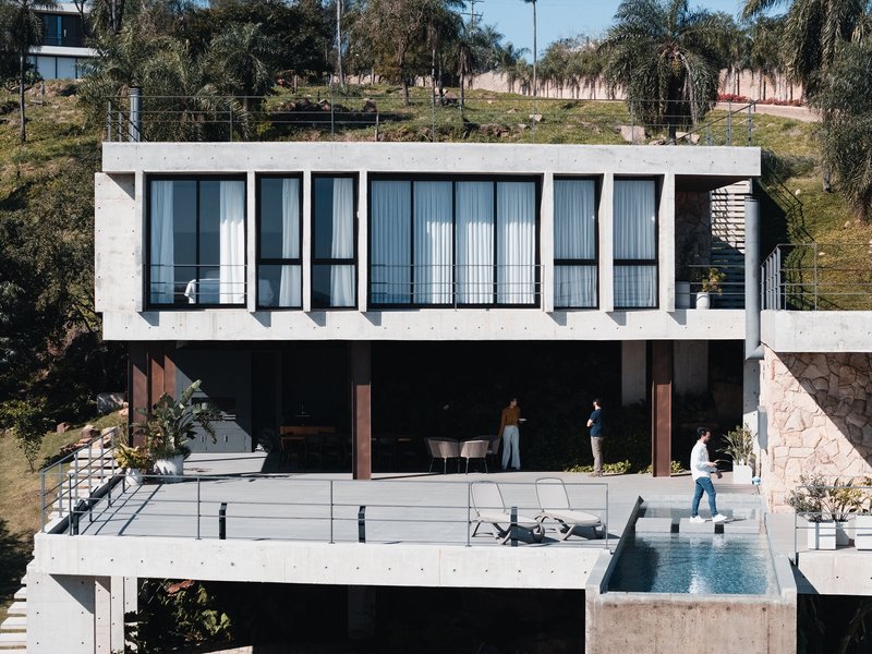 Three levels of terraces with pool and residents visible beneath the upper concrete volume