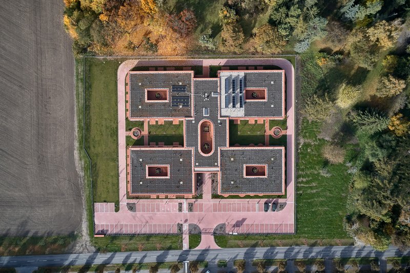 Drone view showing the symmetrical plan with four wings arranged around central courtyards and skylights