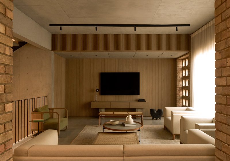 Living space with timber slat wall and perforated brick screen flanking a bright window