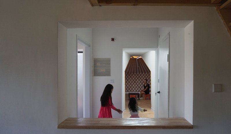 Doorway framing a view through to the yurt interior with its pleated fabric ceiling and lattice walls