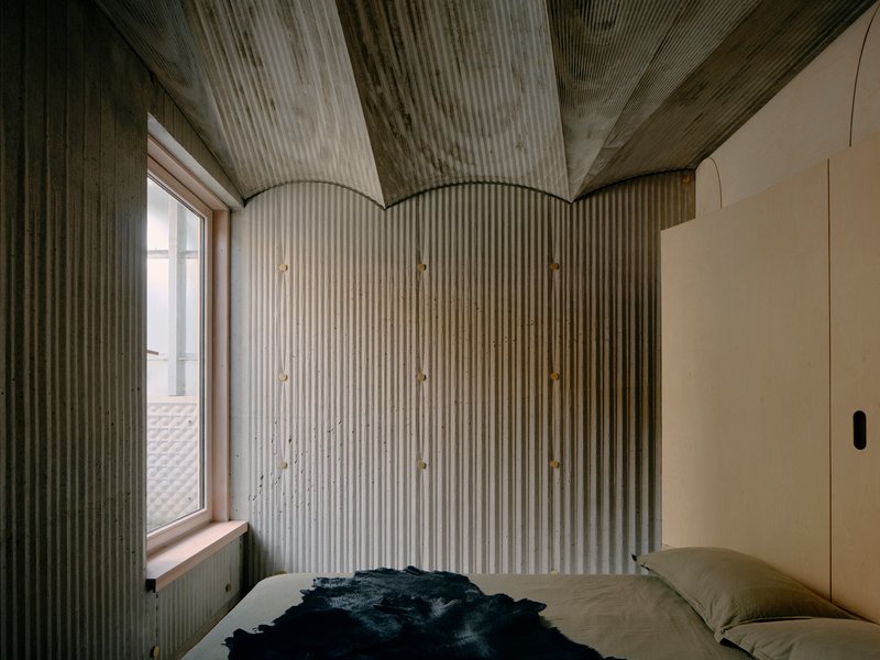 Bedroom corner with ribbed wall paneling meeting the curved vault ceiling at three arched ceiling joins