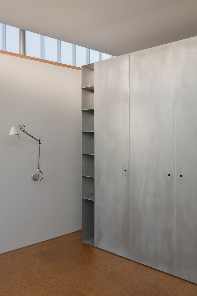 Corner of bedroom showing light grey joinery panels and continuous clerestory glazing above