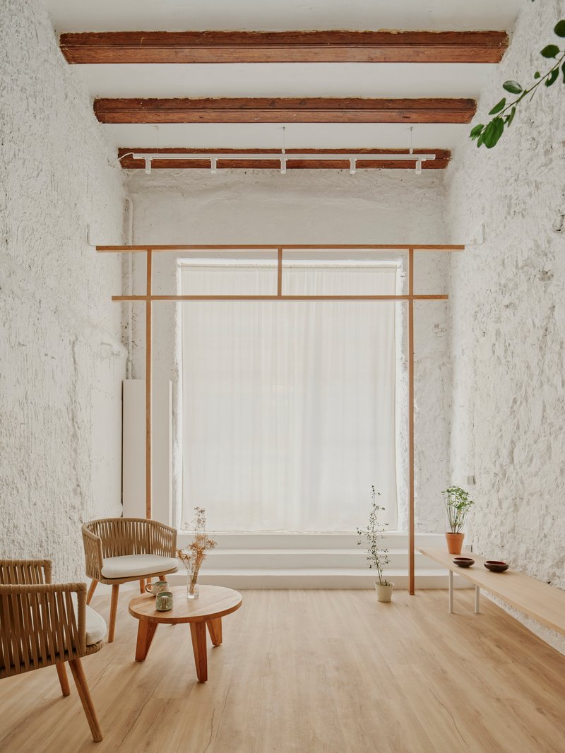 Sitting area with timber frame structure beneath exposed ceiling beams and white render walls