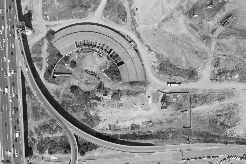 Aerial photograph of the crescent construction site showing excavated earth and formwork beside an adjacent highway
