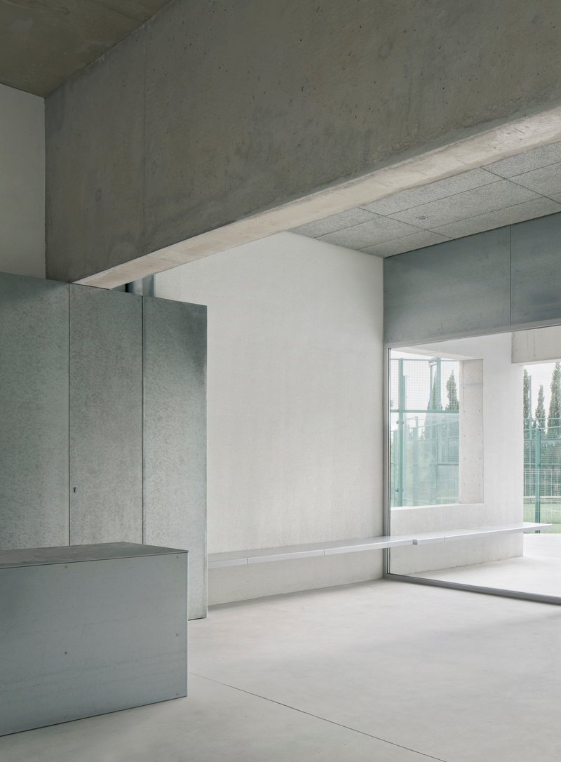 Interior room with concrete ceiling and window framing trees beyond the exterior wall