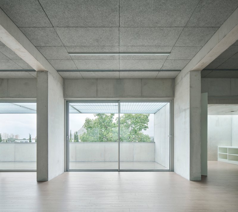 Room with paneled concrete ceiling and sliding glass doors opening to a terrace