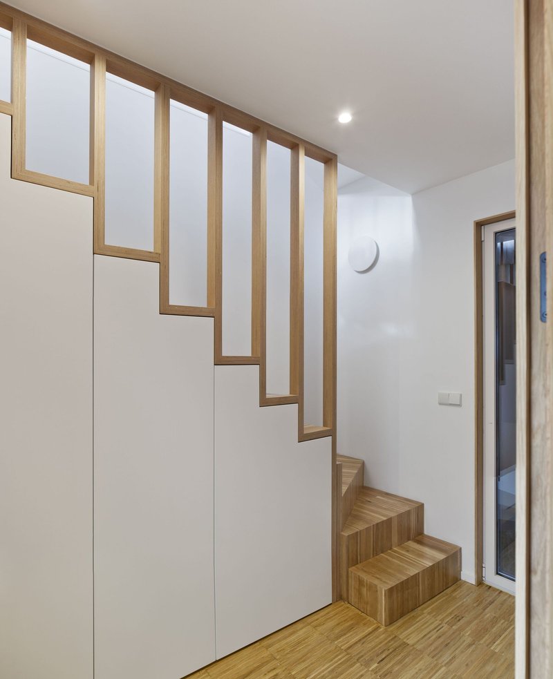 Timber-framed staircase with open risers and integrated storage cabinet along the wall