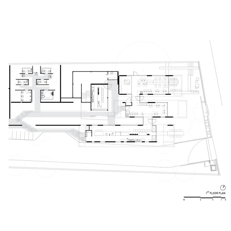 First floor plan drawing showing dining areas, kitchen, office spaces, and a curved outdoor terrace