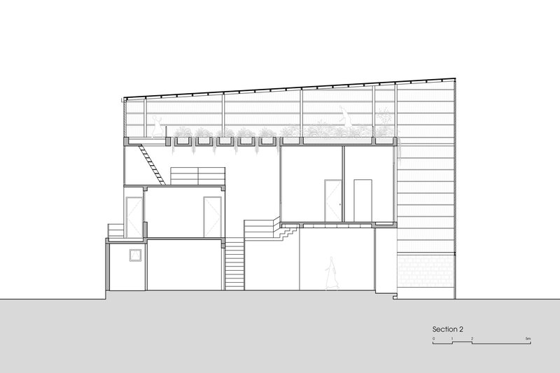 Section drawing showing multi-level interior spaces with stairs connecting volumes beneath a flat roof