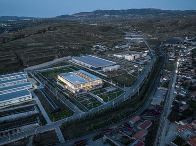 This architectural image showcases a modern industrial complex nestled within a rural landscape. The