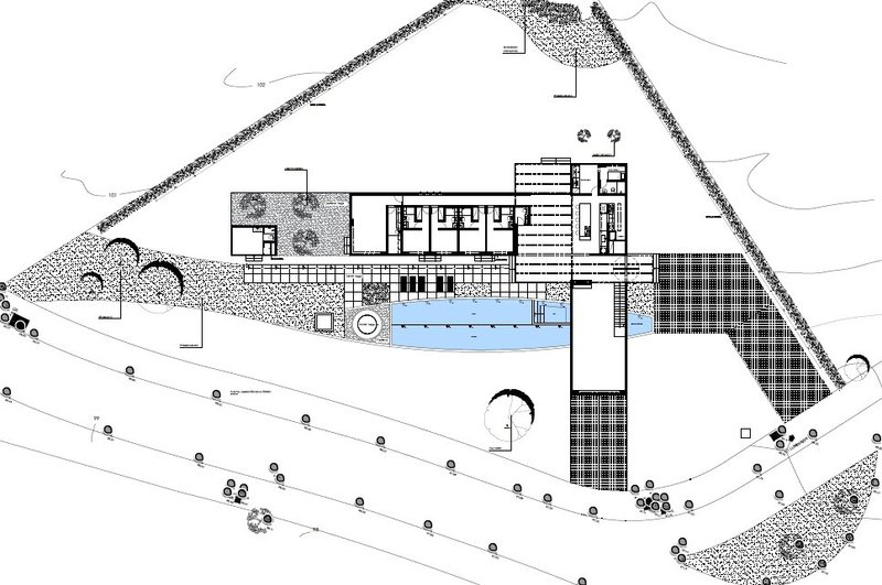 Site plan drawing showing an L-shaped building with a swimming pool and landscaped grounds on a triangular plot