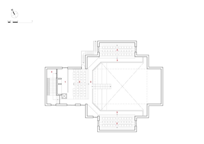 Floor plan showing a central auditorium volume with cruciform seating arrangement and surrounding circulation spaces