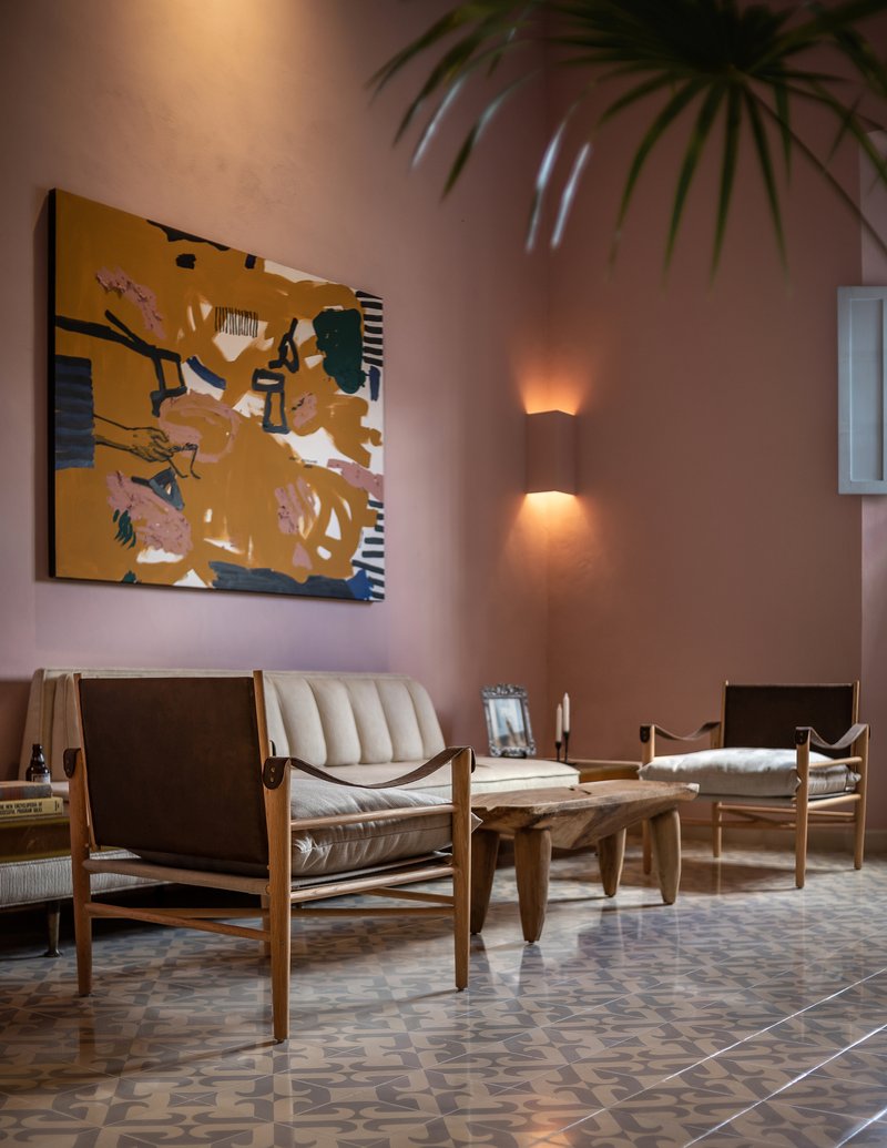 Living room with patterned tile floor, leather lounge chairs, sconce lighting and palm fronds overhead