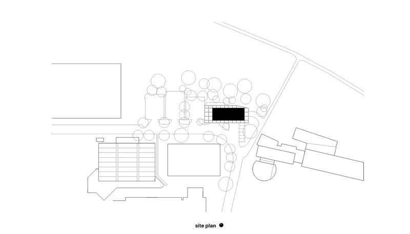 Site plan drawing showing building footprints among circular tree symbols and diagonal roadway