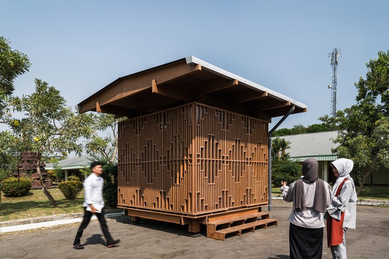 Side view of the pavilion with visitors gathered on the platform in afternoon light