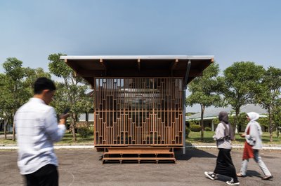 This architectural image showcases a modern pavilion with a distinctive wooden screen facade. The ge