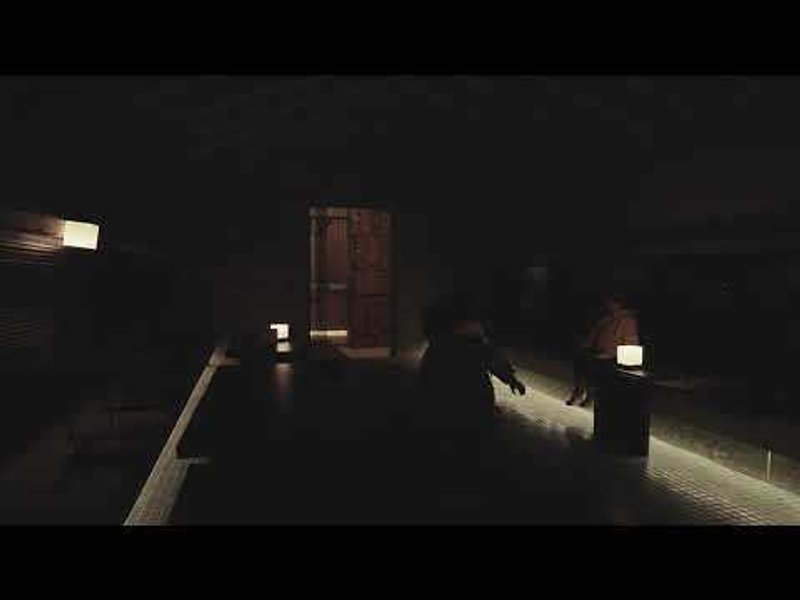 Dark gallery space with spotlit furniture pieces and illuminated display pedestals in atmospheric shadow