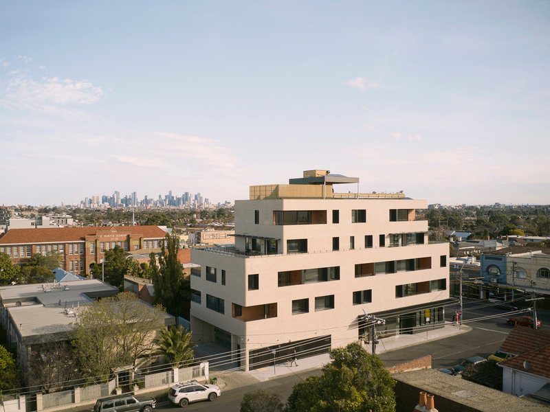 Elevated view of the offset floor plates and rooftop terrace with a distant skyline at dusk