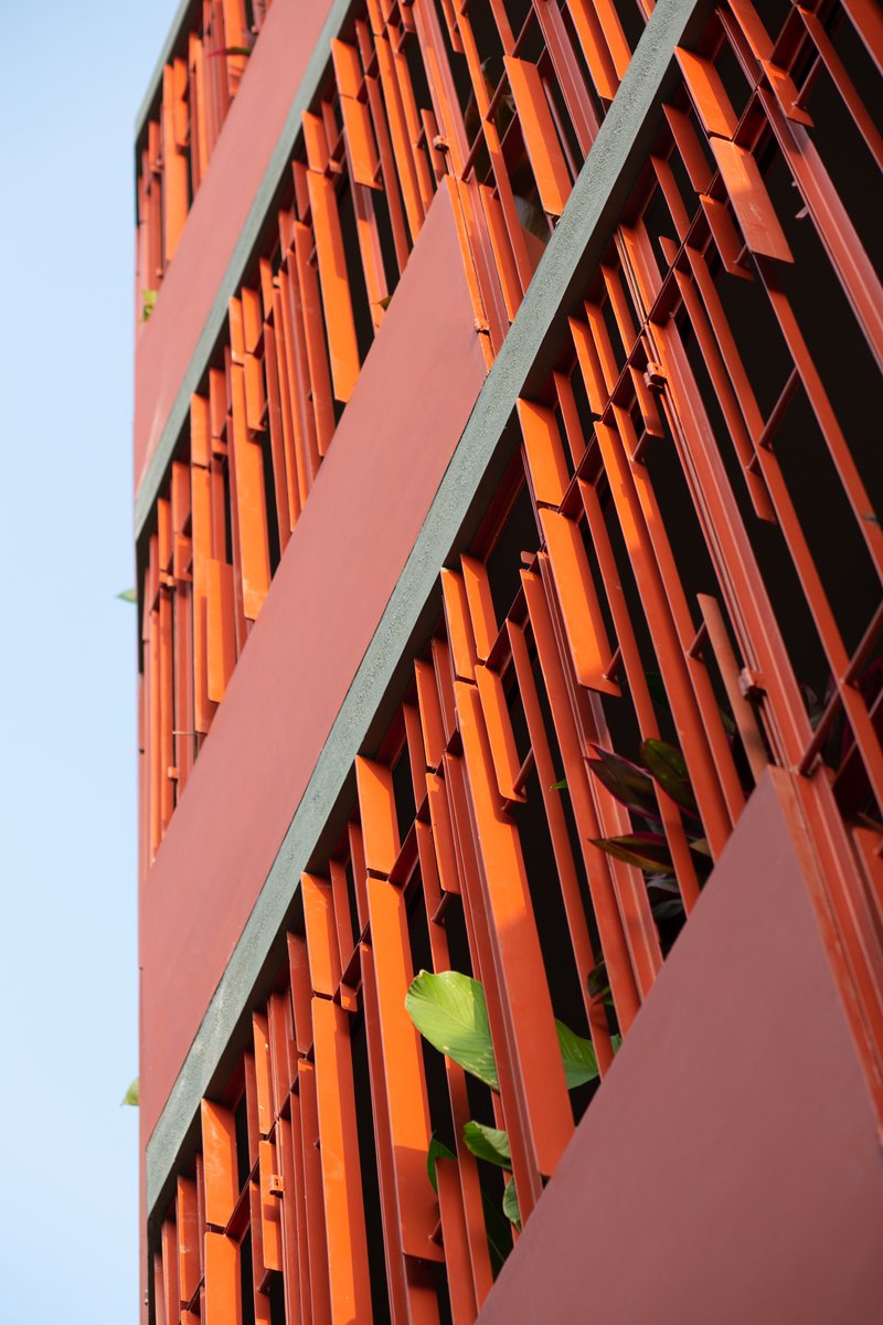 Close-up of the red vertical batten screen with sunlight filtering through the gaps