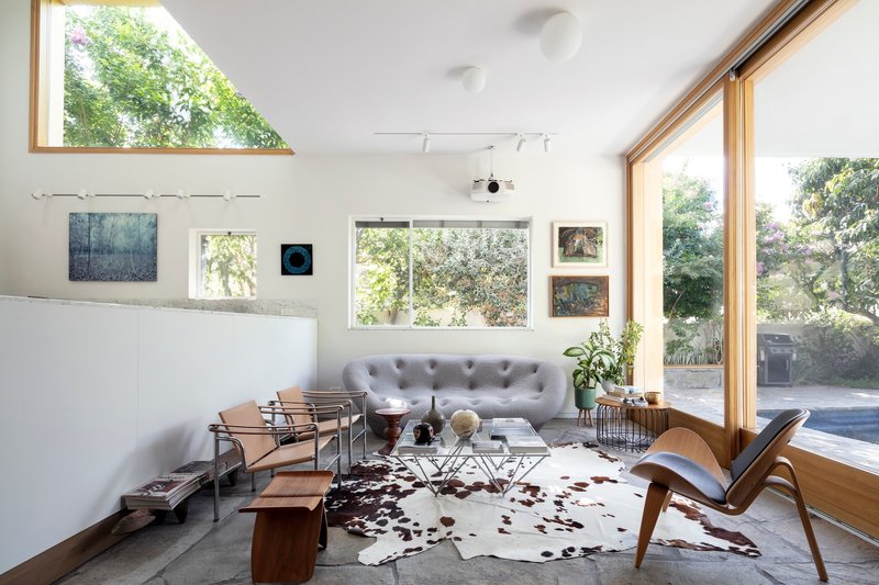 Living room with triangular clerestory window and full-height glazing overlooking the garden