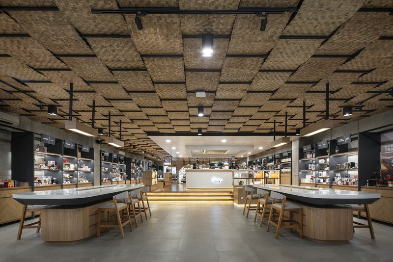 Tasting counter with wooden stools under a suspended woven bamboo ceiling panel system