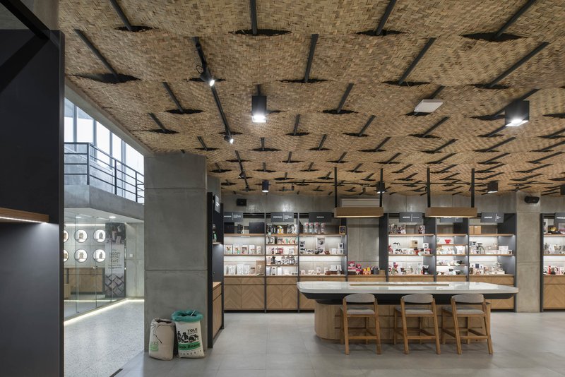 Interior view of the undulating bamboo ceiling above product shelving and seating area