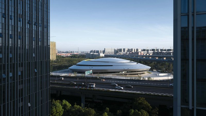 Stacked disc roof forms viewed between curtain wall facades under a clear sky
