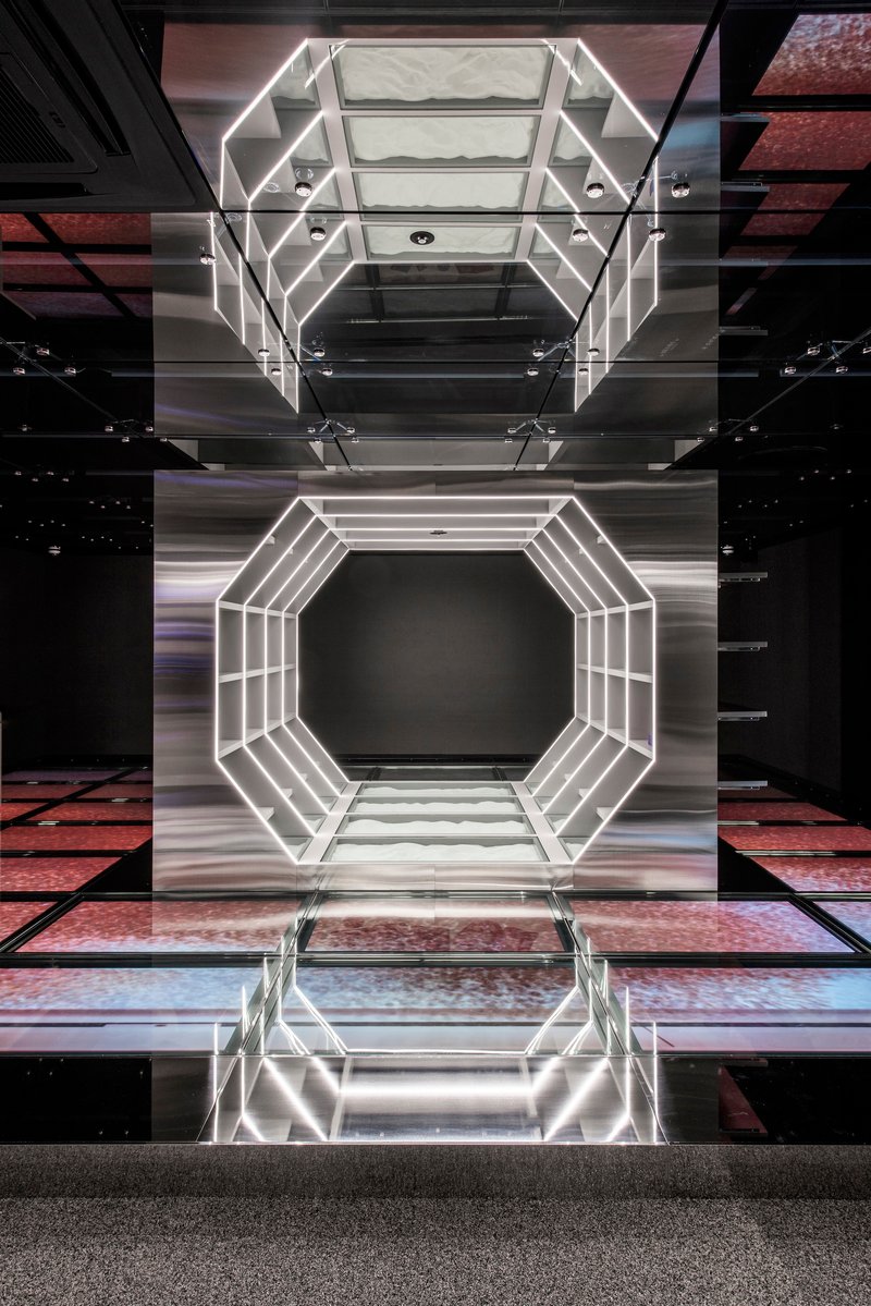 Vertical atrium view showing octagonal light frame reflected in polished floor below