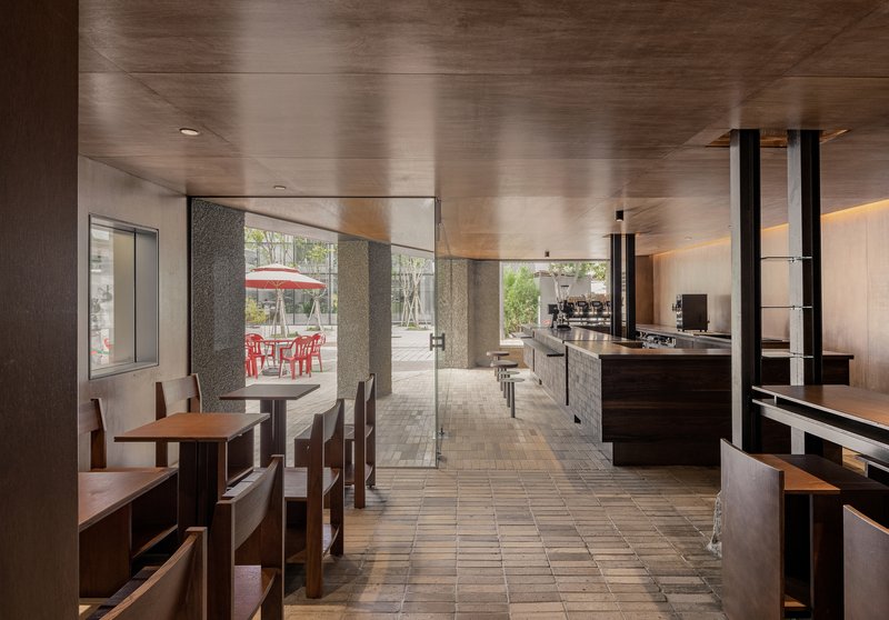 Interior view through the seating area toward the glazed entrance and outdoor courtyard