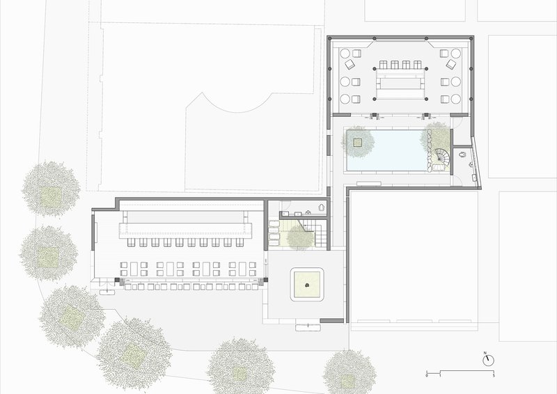 Ground floor plan drawing showing rectangular volumes with courtyards and surrounding trees rendered in light green