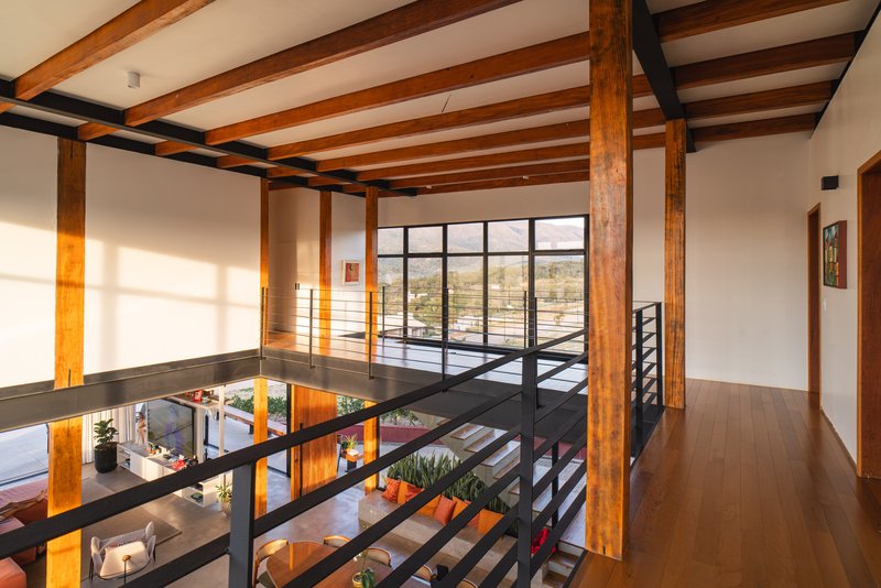Second floor walkway with black steel railings and timber columns overlooking the double-height space below