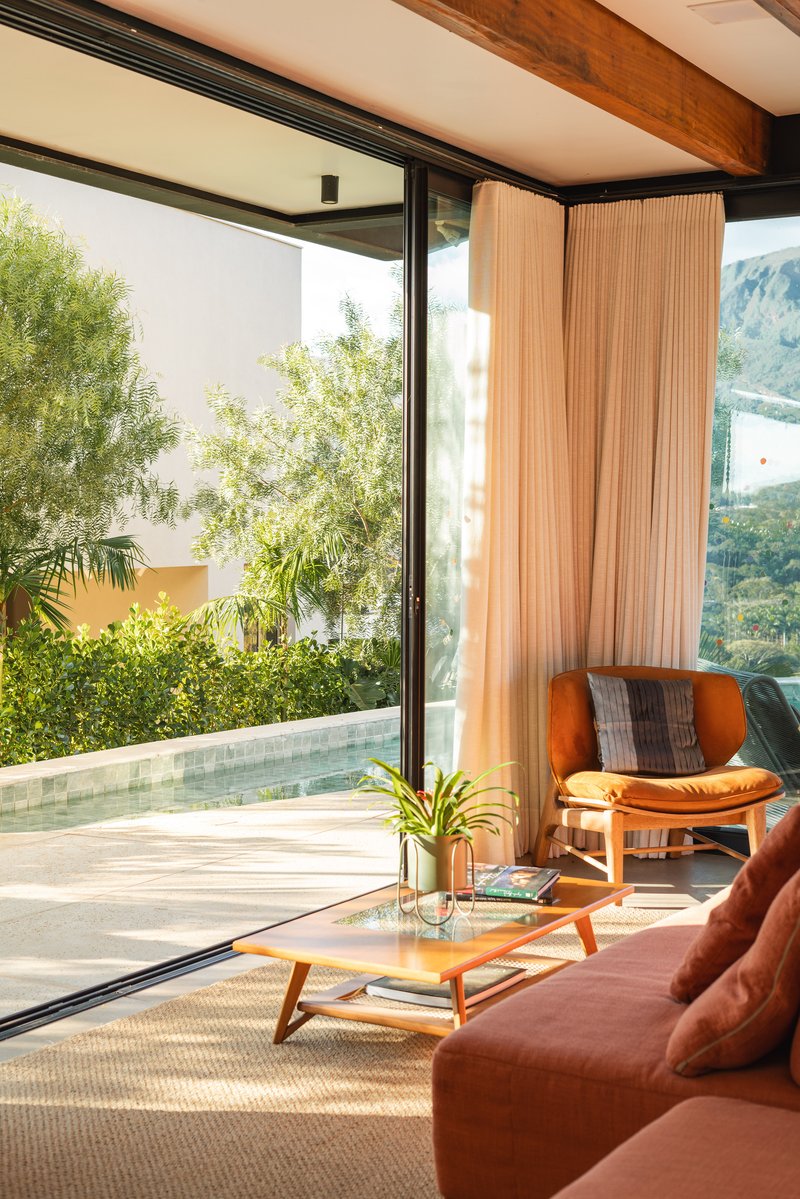 Interior corner showing vertical timber panels beside sliding glass doors and mountain views beyond