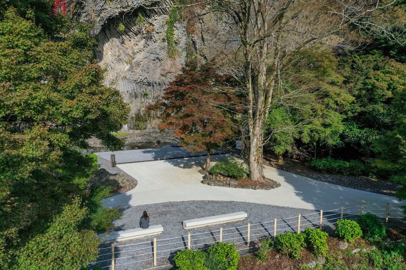 Branching concrete paths surrounding a planted circle with deciduous trees in autumn foliage