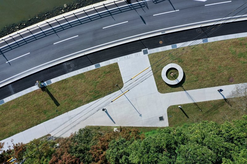 Aerial view of the concrete plaza intersecting roadway and lawn with circular planted opening