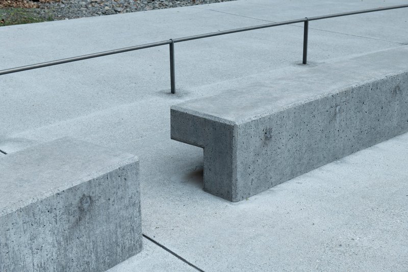 Detail of cast concrete bench with notched corner joint and steel railing posts