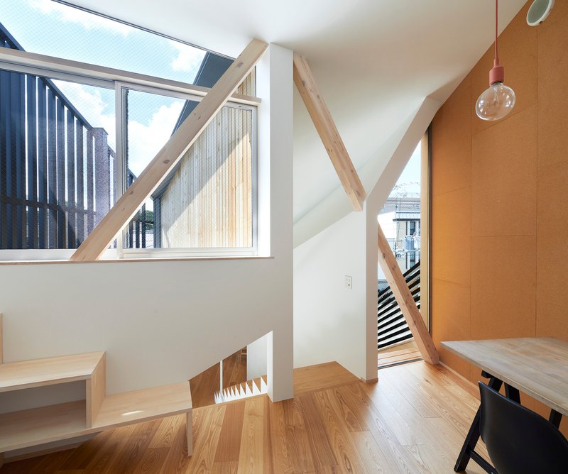Upper landing with diagonal timber beam and glazed skylight overlooking the stairwell and courtyard