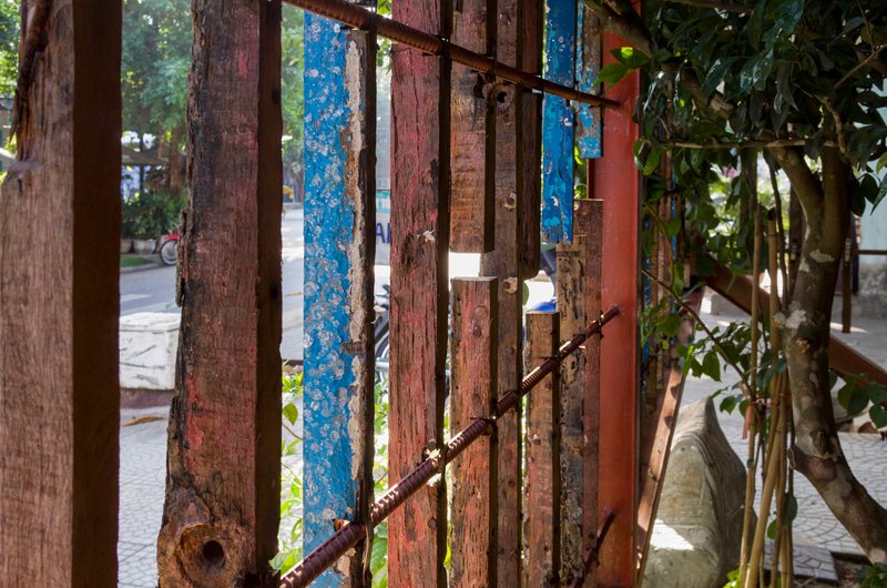 Vertical screen of salvaged painted timber slats framing view to street and planted courtyard